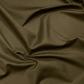 A close-up of draped olive green fabric with soft folds and a smooth texture.
