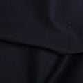 A close-up of dark navy fabric with soft folds and a smooth texture.