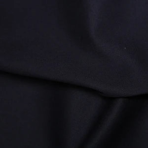 A close-up of dark navy fabric with soft folds and a smooth texture.