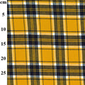 A close-up of a plaid fabric pattern with a vertical measurement scale on the left side in centimeters. The pattern features mustard yellow, dark navy blue, olive green, and white intersecting stripes.