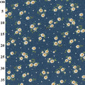 A close-up of a navy blue fabric with a repeating pattern of small white daisies with yellow centers, green stems, and scattered white dots, with a vertical measurement scale in centimeters on the left side.