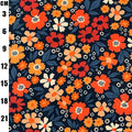 A close-up of a floral fabric pattern with orange, red, and cream flowers, dark blue leaves, and small white dots on a dark navy background, with a black measurement scale on the left side showing centimeter increments.