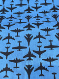 A close-up of a blue fabric with a repeating pattern of black airplane silhouettes.