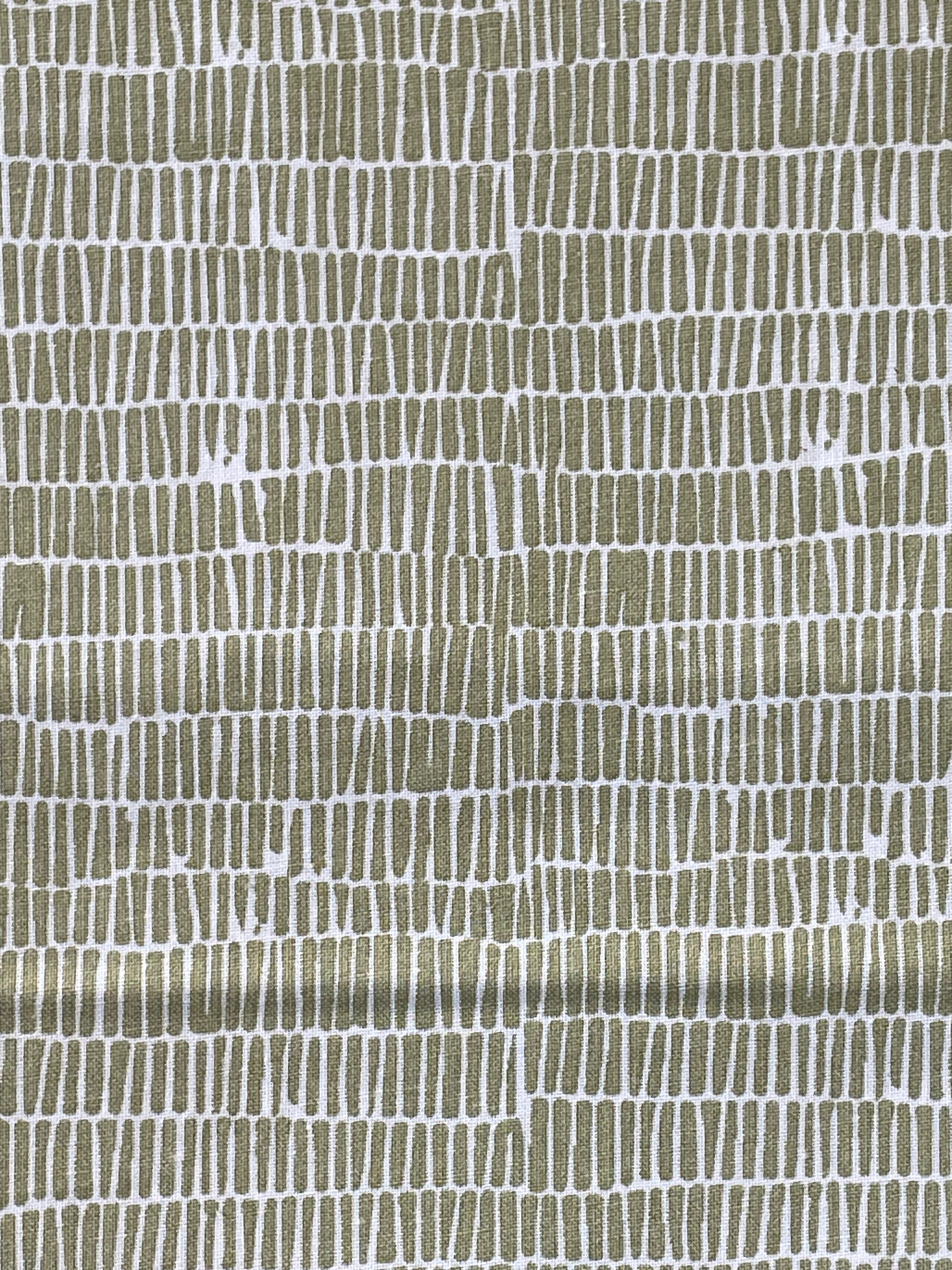 A close-up of a textured fabric pattern featuring a metallic olive-gold and white hand-drawn vertical line design.