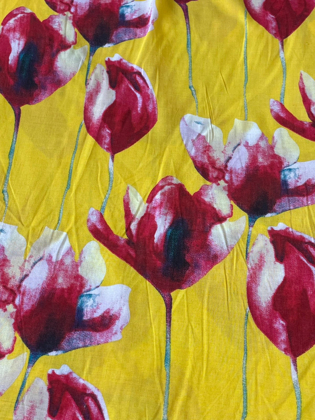 Yellow fabric with a watercolor-style floral print featuring red, burgundy, and white tulip-like flowers with thin green stems.