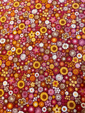 A dense, all-over floral pattern featuring small daisy-like flowers in yellow, orange, pink, red, white, and brown on a dark red background.