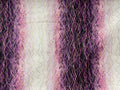 A close-up of a textured fabric featuring vertical wavy stripes in shades of purple, pink, and black, overlaid with fine gold-colored stitched lines.