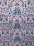 A close-up of a fabric pattern featuring an intricate floral and vine design in navy blue, pink, cream, and gold on a light blue-gray background.