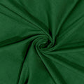 A close-up of dark green fabric arranged in a spiral drape, showing the material texture and color.