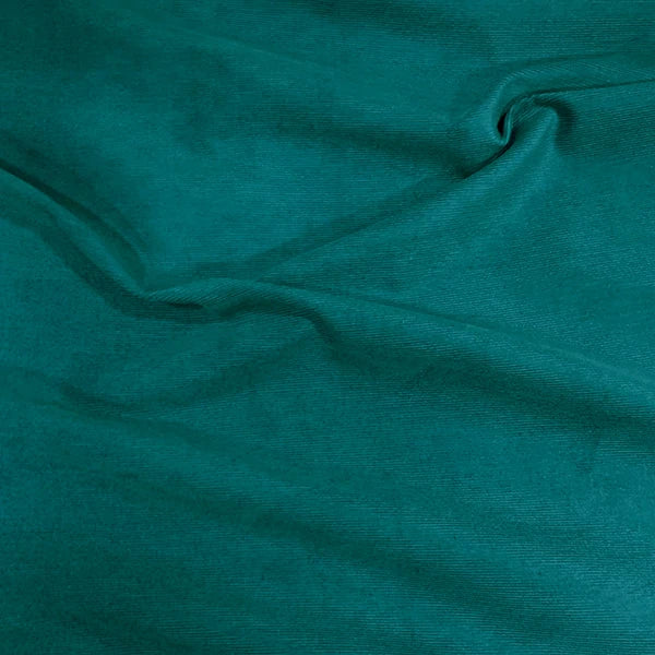 A close-up of draped teal fabric with soft folds and a smooth texture.