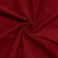 A close-up of deep red fabric arranged in a spiral drape, showing the material texture and color.