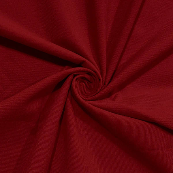 A close-up of deep red fabric arranged in a spiral drape, showing the material texture and color.