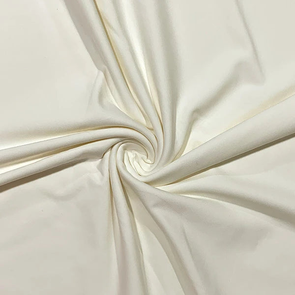 A close-up of cream-colored fabric arranged in a spiral drape, showing its smooth texture and soft folds.