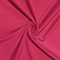 A close-up of bright pink fabric arranged in a spiral drape, showing the material texture and color.