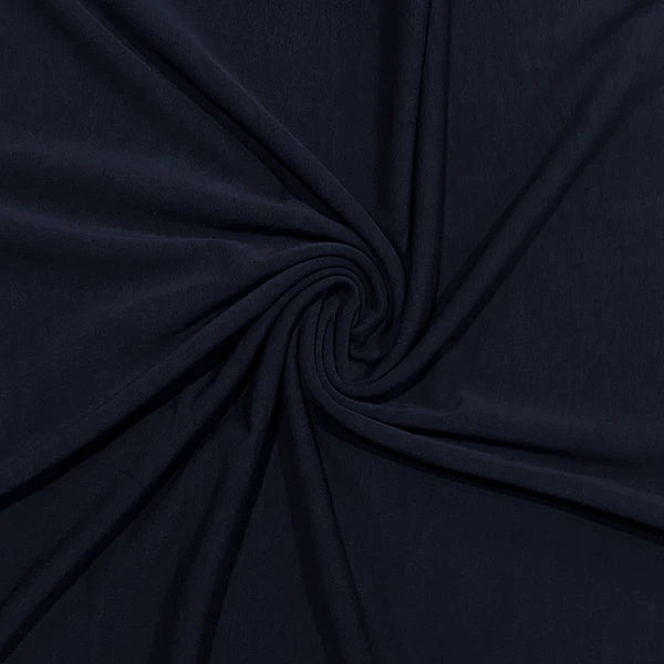 A close-up of dark navy blue fabric arranged in a spiral drape, showing the material's texture and color.