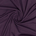 A close-up of dark purple fabric arranged in a spiral drape, showing the material texture and color.