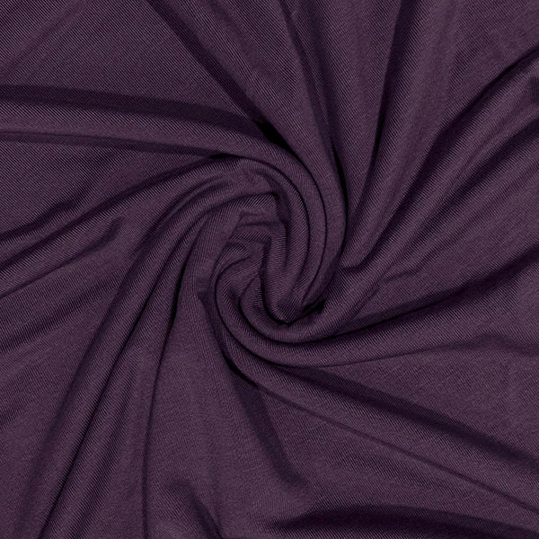 A close-up of dark purple fabric arranged in a spiral drape, showing the material texture and color.