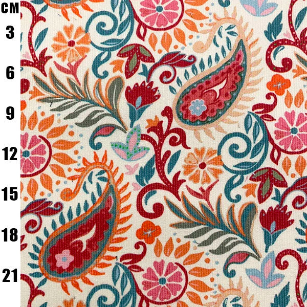 A close-up of a fabric pattern featuring a colorful paisley and floral design on a cream background, with a black centimeter measurement scale printed along the left edge.