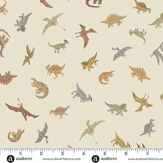 A repeating fabric pattern featuring various cartoon-style dinosaurs in muted brown, tan, gray, and green tones on a warm beige background. A white measurement ruler with black markings is shown along the bottom edge, and the brand name 'andover' appears at the bottom.