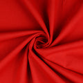A close-up of bright red linen fabric arranged in a spiral swirl, showing the material texture and drape.