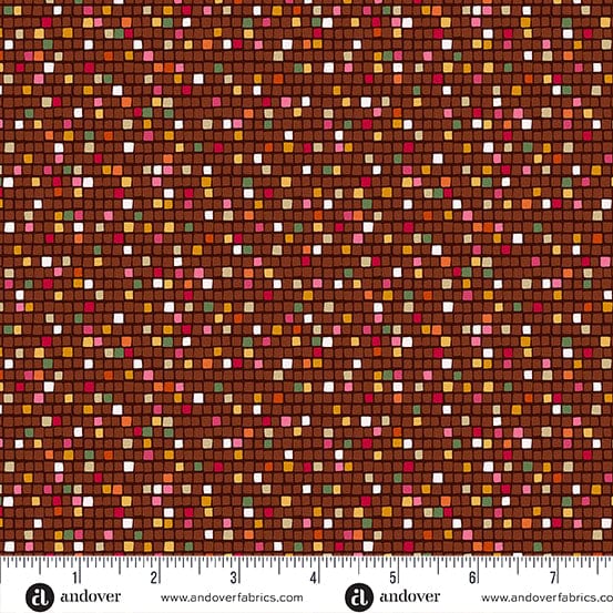 A close-up of a fabric pattern featuring a brown background covered in small, densely packed multicolored square tiles in shades of red, orange, yellow, green, pink, and white. A white ruler with black markings and the 'andover' brand logo is visible along the bottom edge.