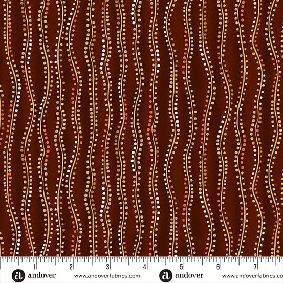 A close-up of a fabric pattern featuring vertical wavy lines in dark brown, rust red, and beige, decorated with dotted Aboriginal-style dot art. A white ruler with black markings and the brand name 'andover' is visible along the bottom edge.